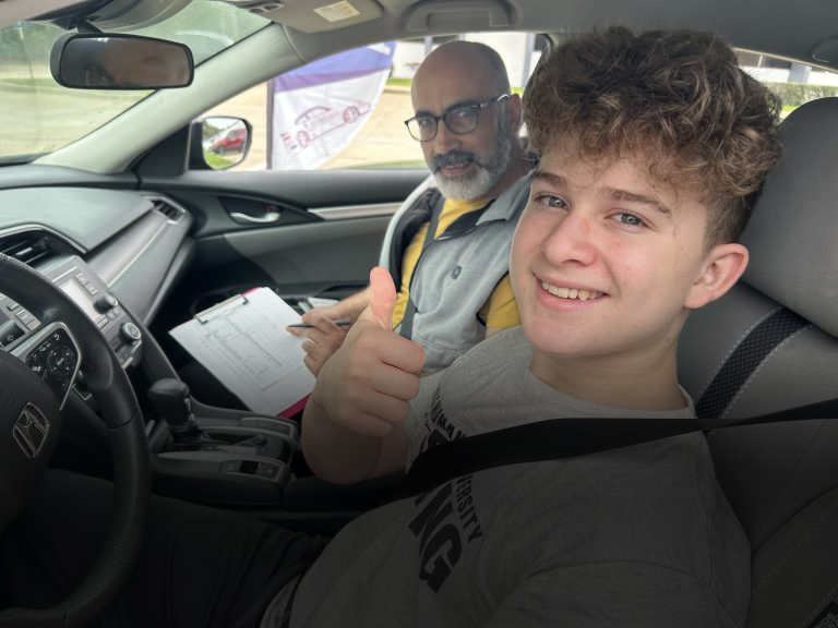 Teen driver with instructor inside a training vehicle