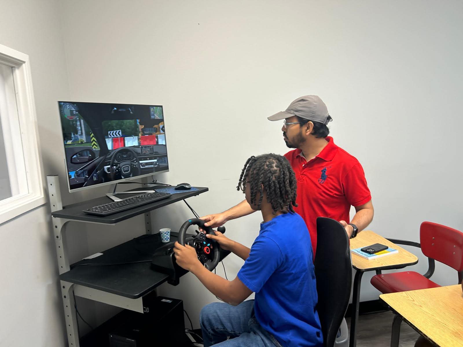 Instructor coaching a student on a driving simulator