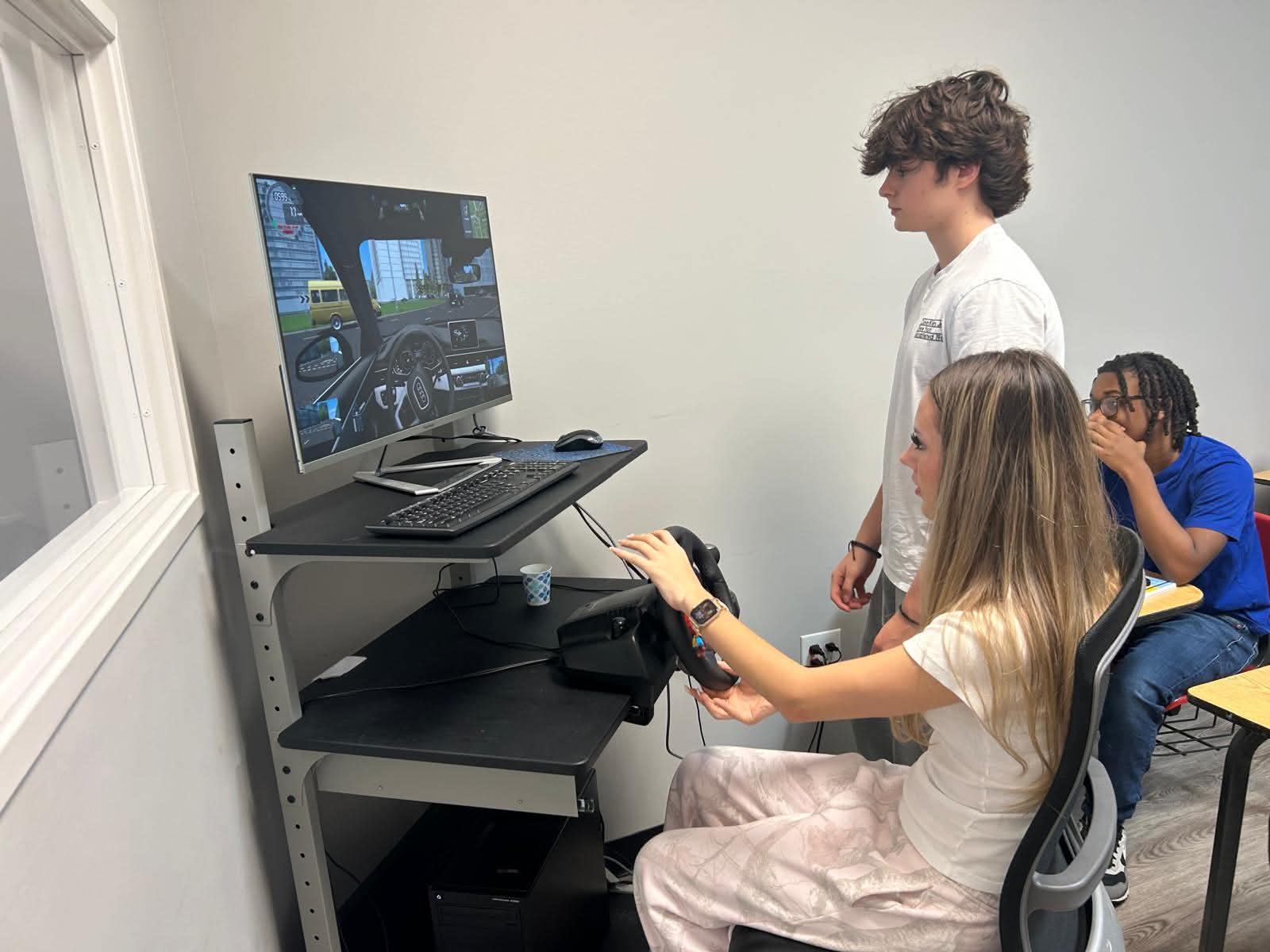 Students learning together on a driving simulator